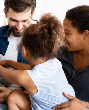 Father and young daughter in a family therapy session with a therapist taking notes
