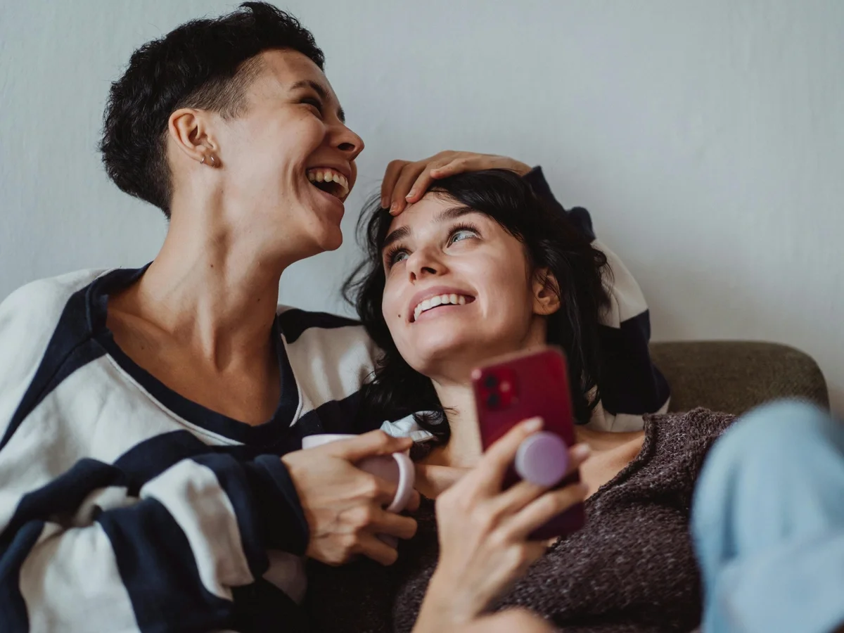 Two people sharing a warm laugh together on the couch
